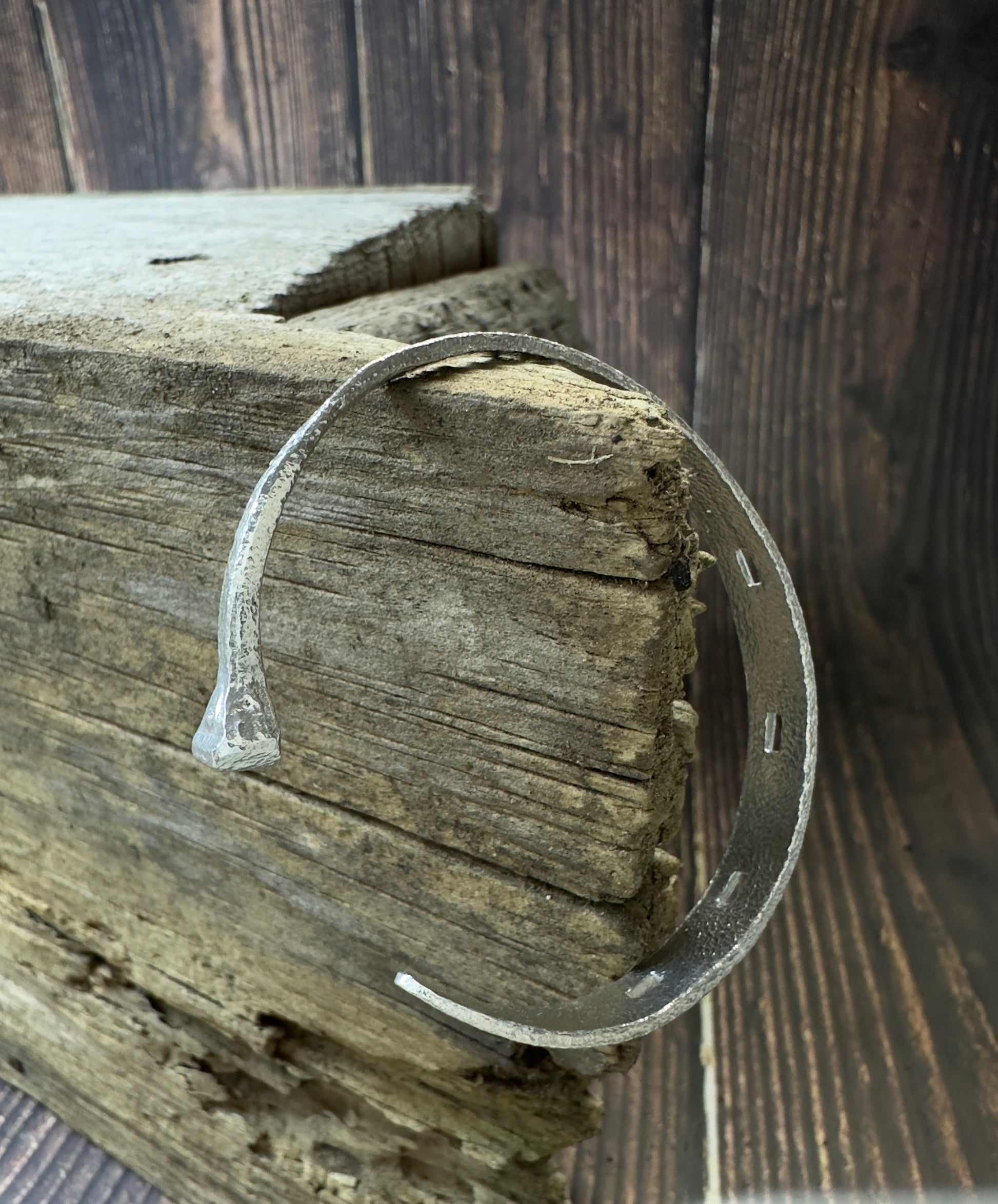 Sterling silver cuff bracelet, hand forged to resemble a horseshoe with a horseshoe nail on one end. Handmade made by a farrier/jeweler