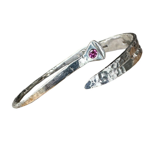 Silver bracelet with a pink gemstone on a white background